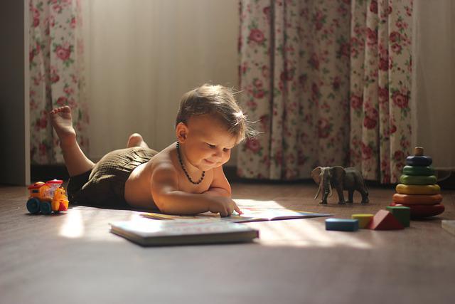 Un bebé, rodeado de juguetes, ríe con una lectura