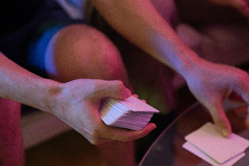 Una persona mezclando cartas con las manos.
