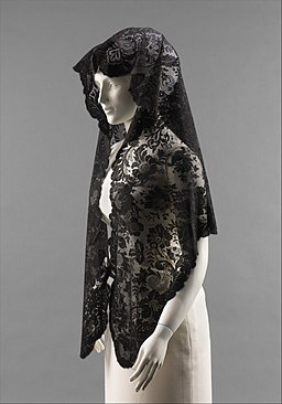 Una tela bordada y de color negro, que cubre la cabeza de una mujer.