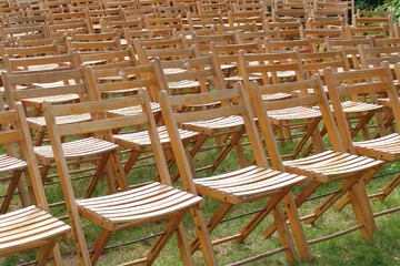 Imagen donde aparecen muchas sillas plegables de madera