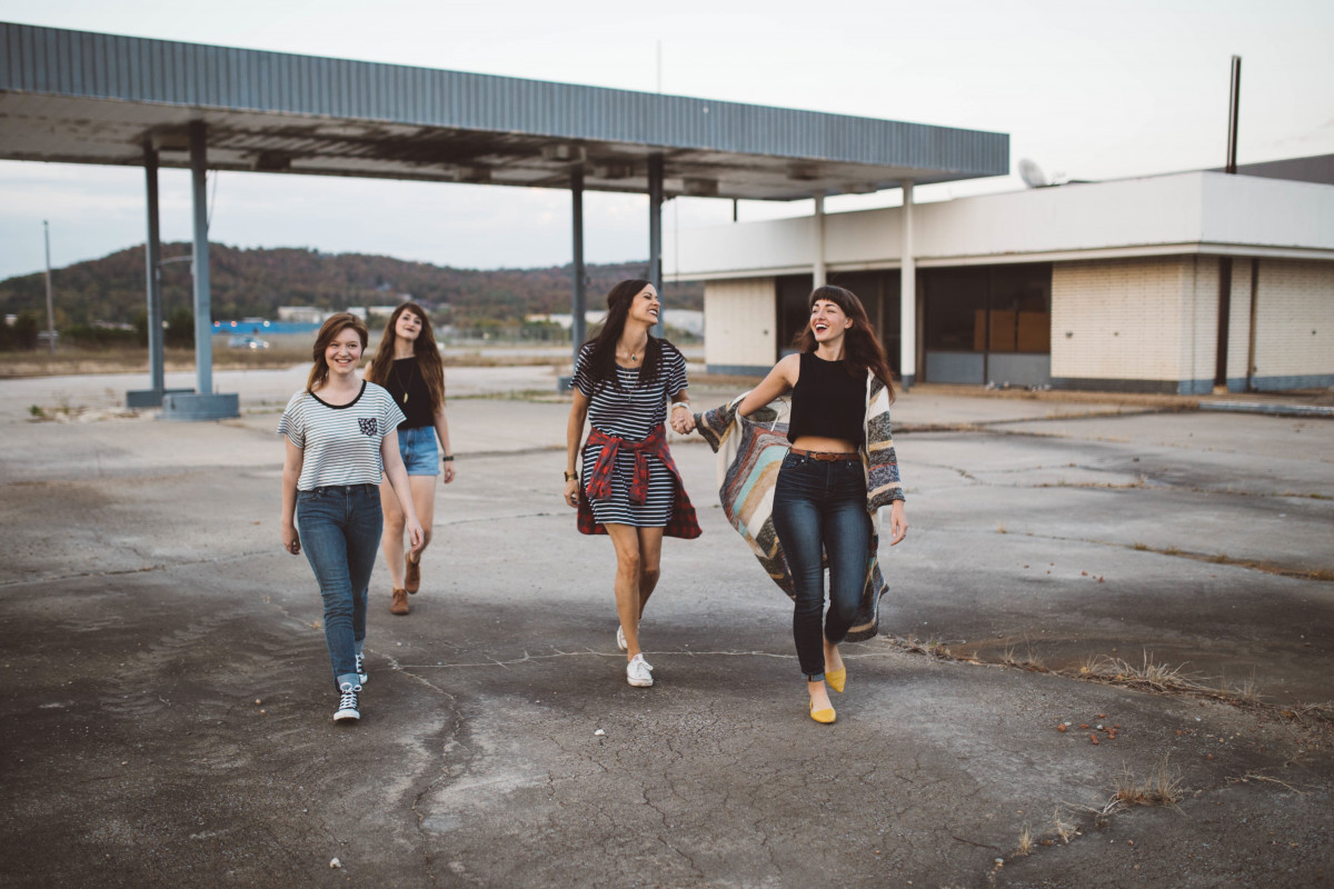 La imagen muestra un grupo de cuatro adolescentes caminando.