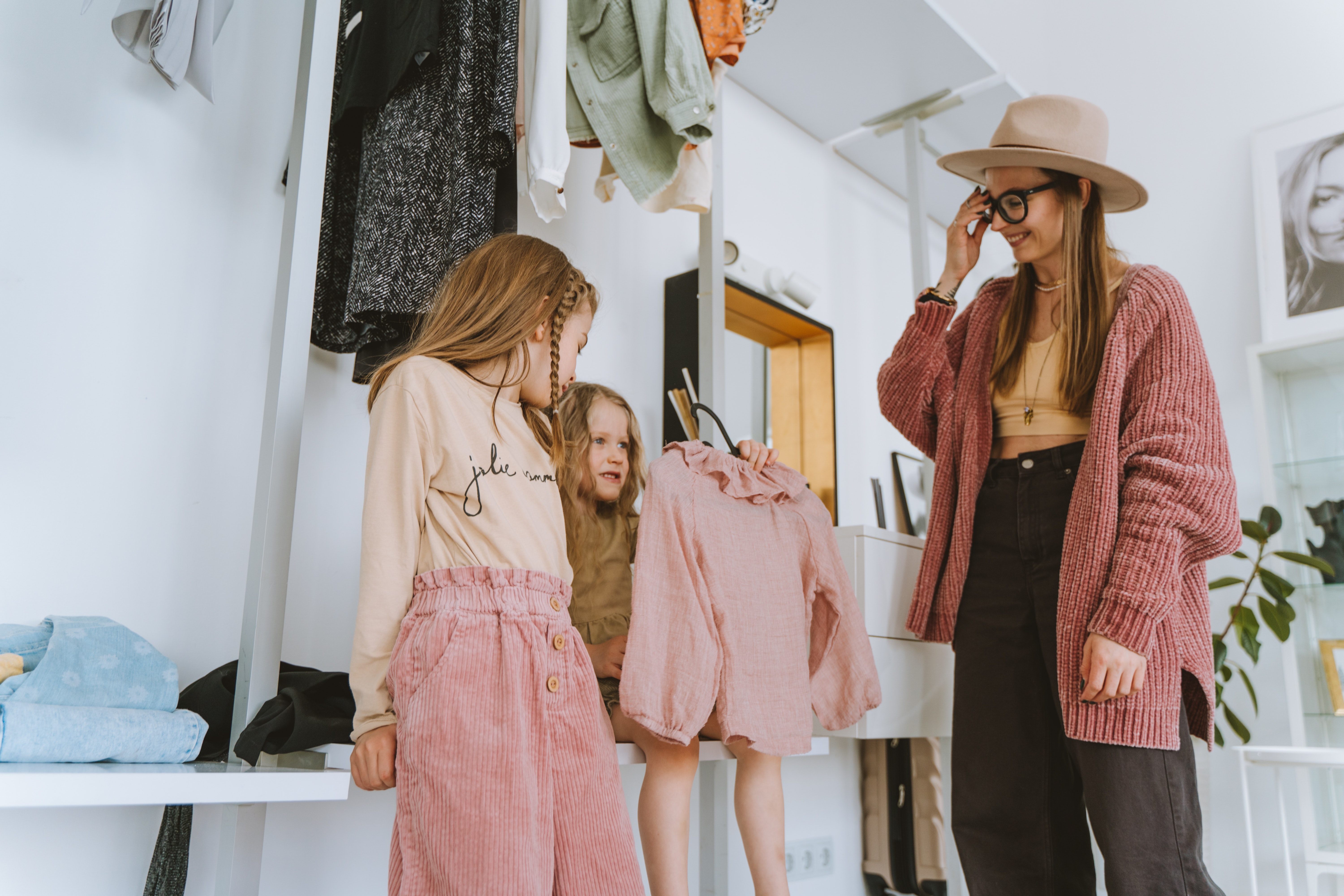 La imagen muestra tres chicas eligiendo ropa.