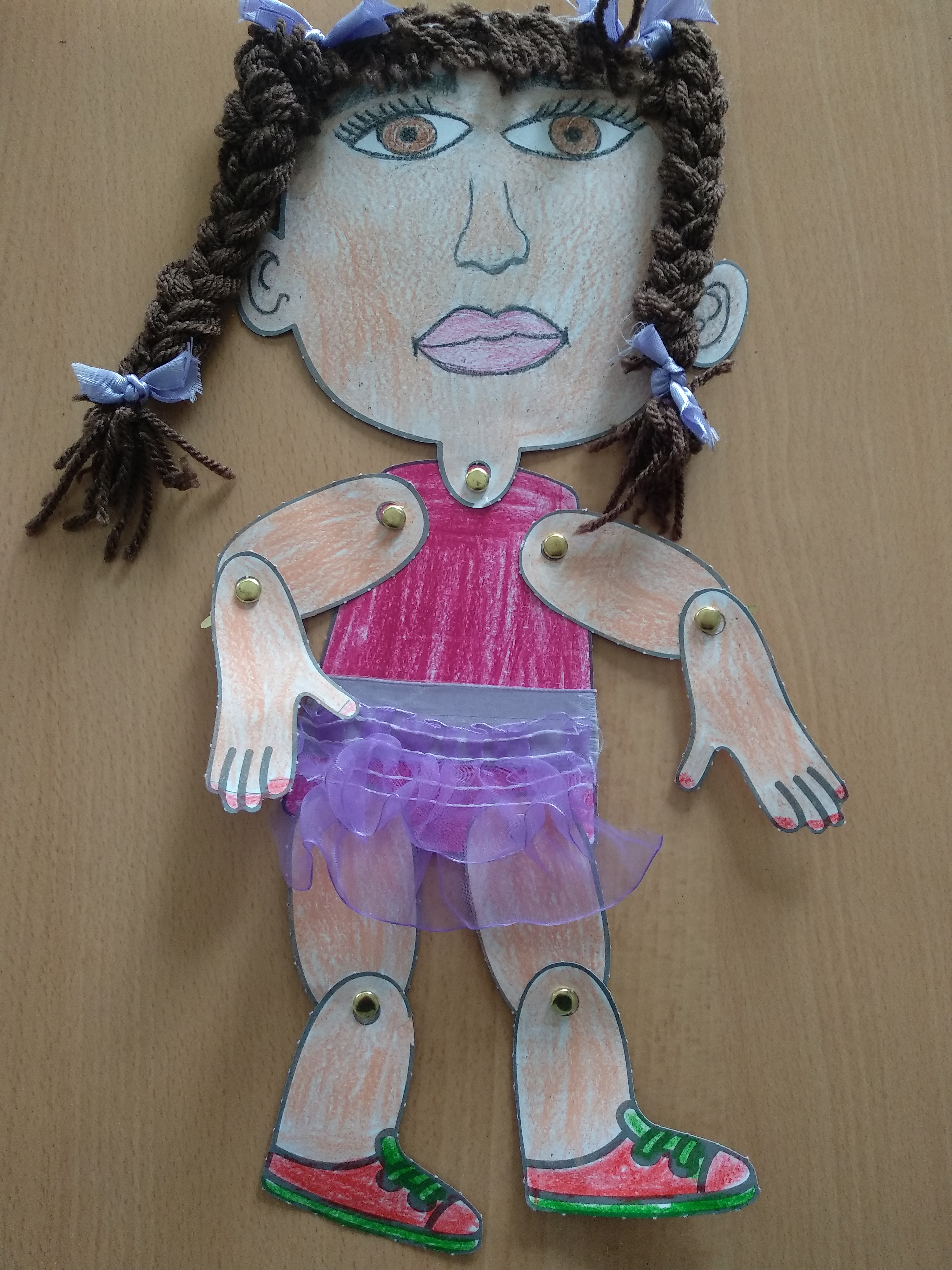 La imagen muestra una marioneta de una niña con trenzas.