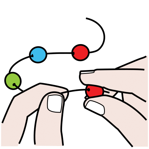La imagen muestra unas manos pasando un hilo por unas bolas de colores