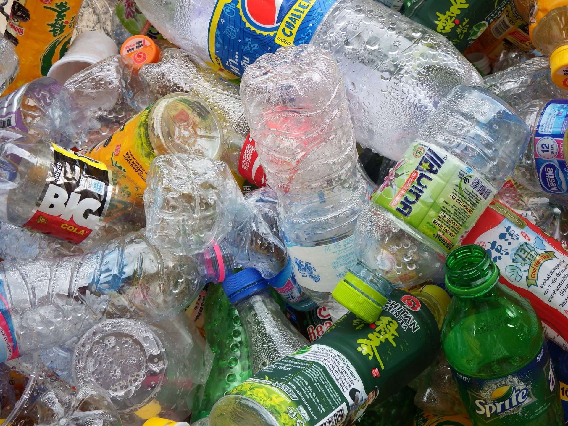 La imagen muestra botellas de plástico amontonadas, de diferentes formas y tamaños