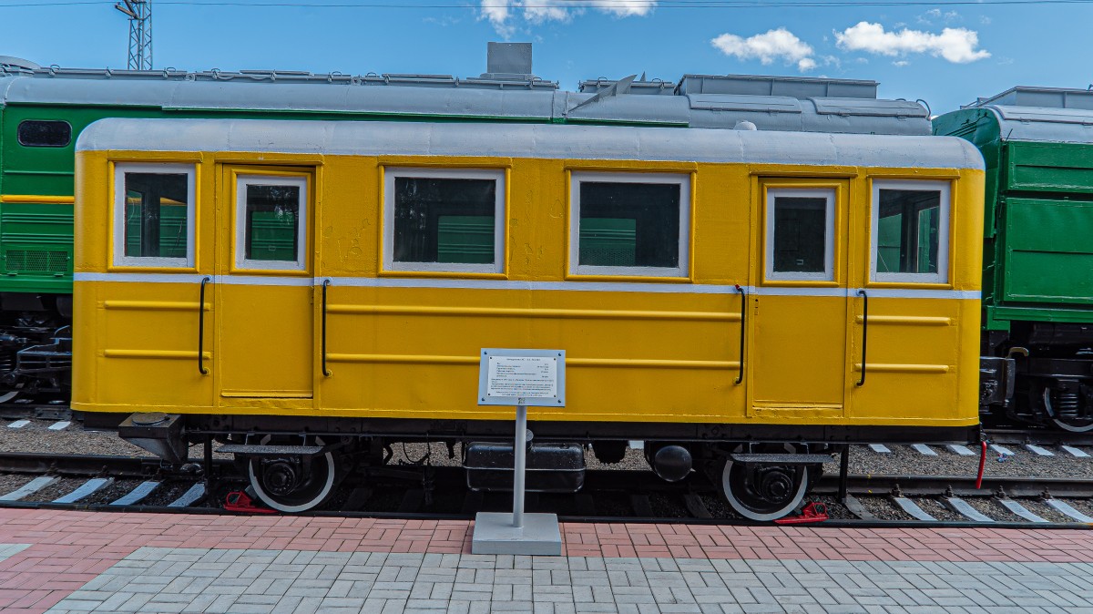 La imagen muestra un vagón de tren de color amarillo