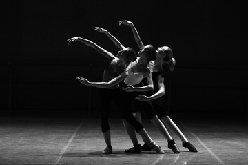 Tres bailarinas en un escenario.