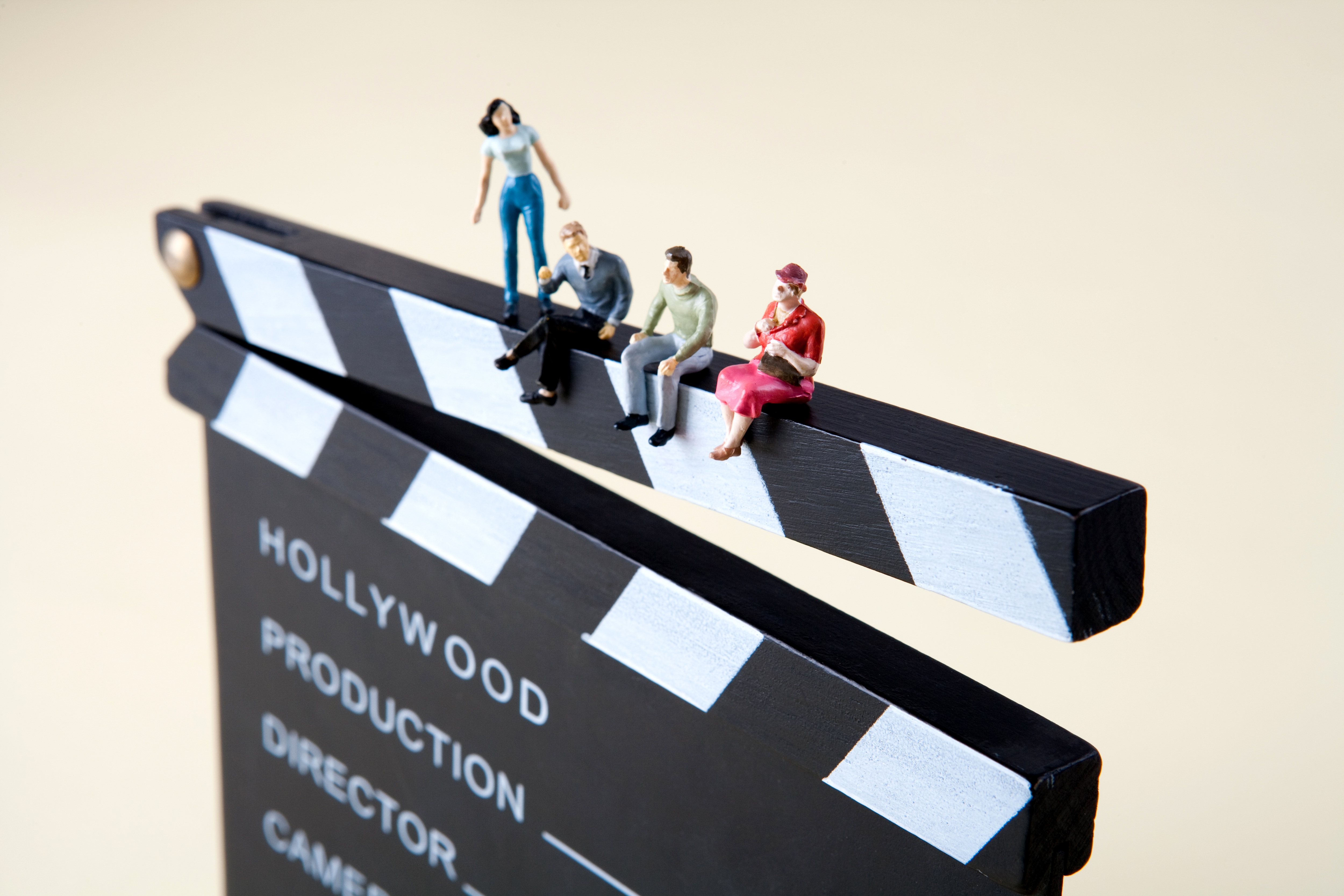 Claqueta de cine con los textos “Hollywood”, “Production”, “Director” y cuatro figuras en su borde superior, a modo de personajes