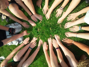 Imagen de pies y manos de diferentes personas formando un círculo