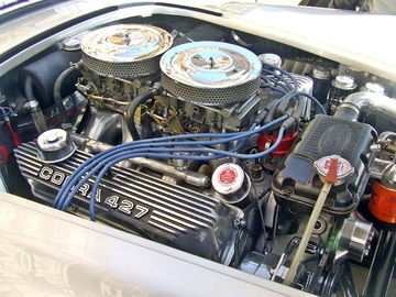 motor de un coche que tiene el capó abierto