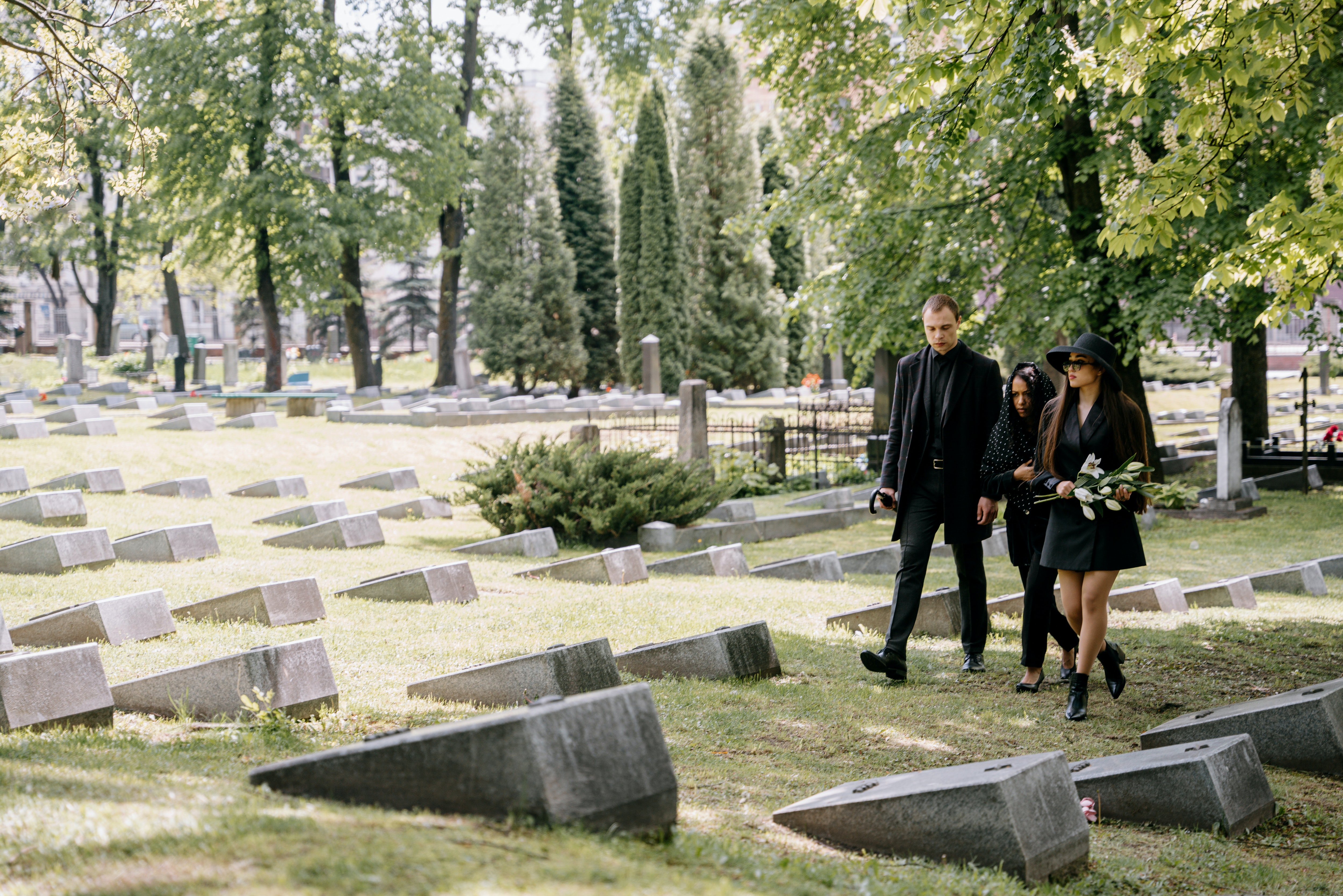 Familia vestida de negro en un cementerio visitando a sus difuntos.