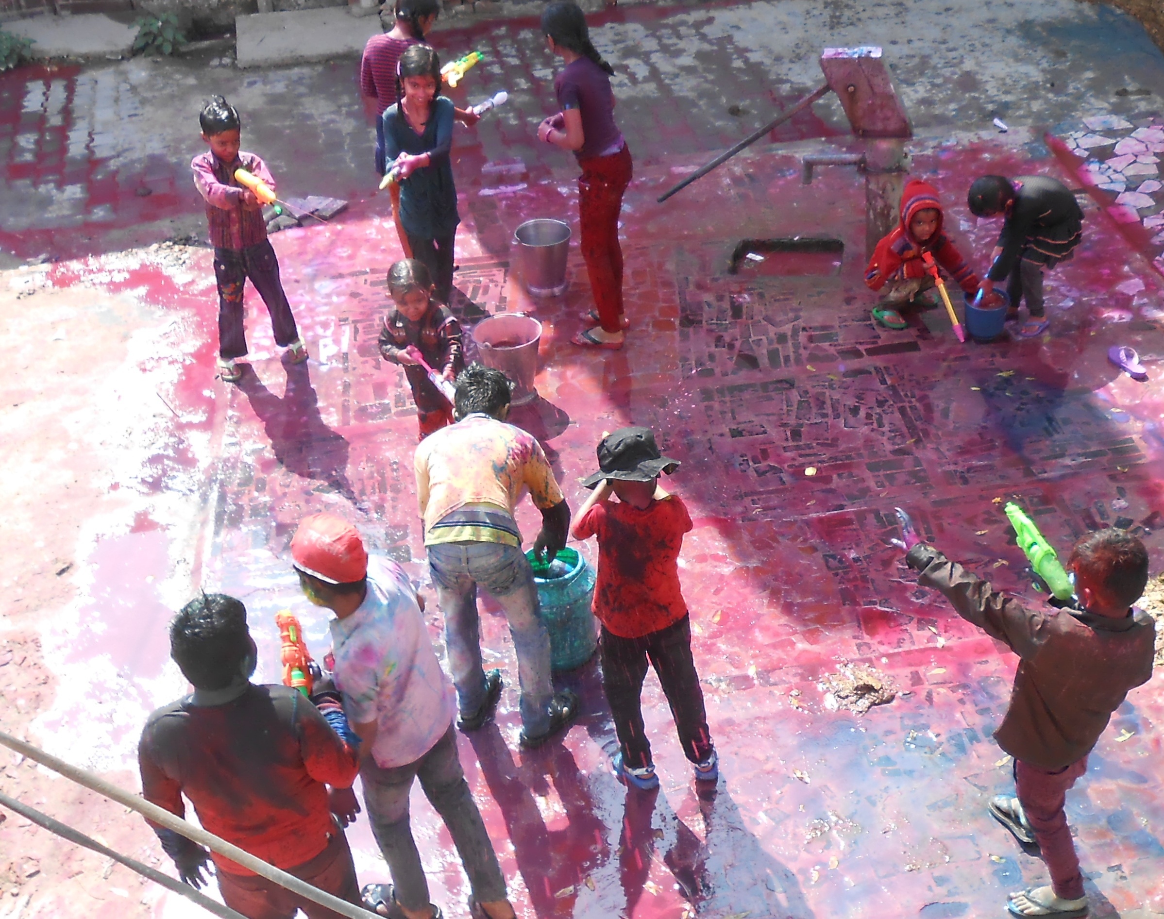 Niños jugando con pintura y pistolas de agua.