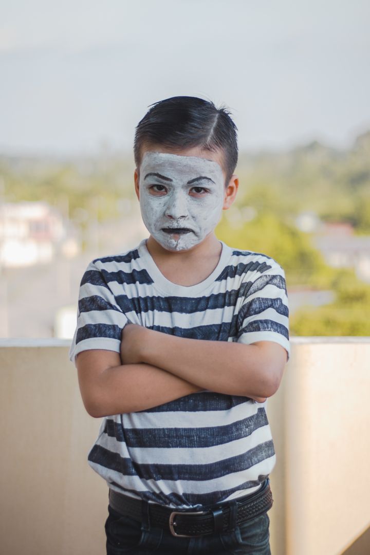 Fotografía de un niño mimo con la cara pintada con gesto enfadado.