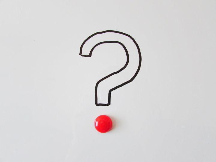 Fotografía de una interrogación con un botón como punto.