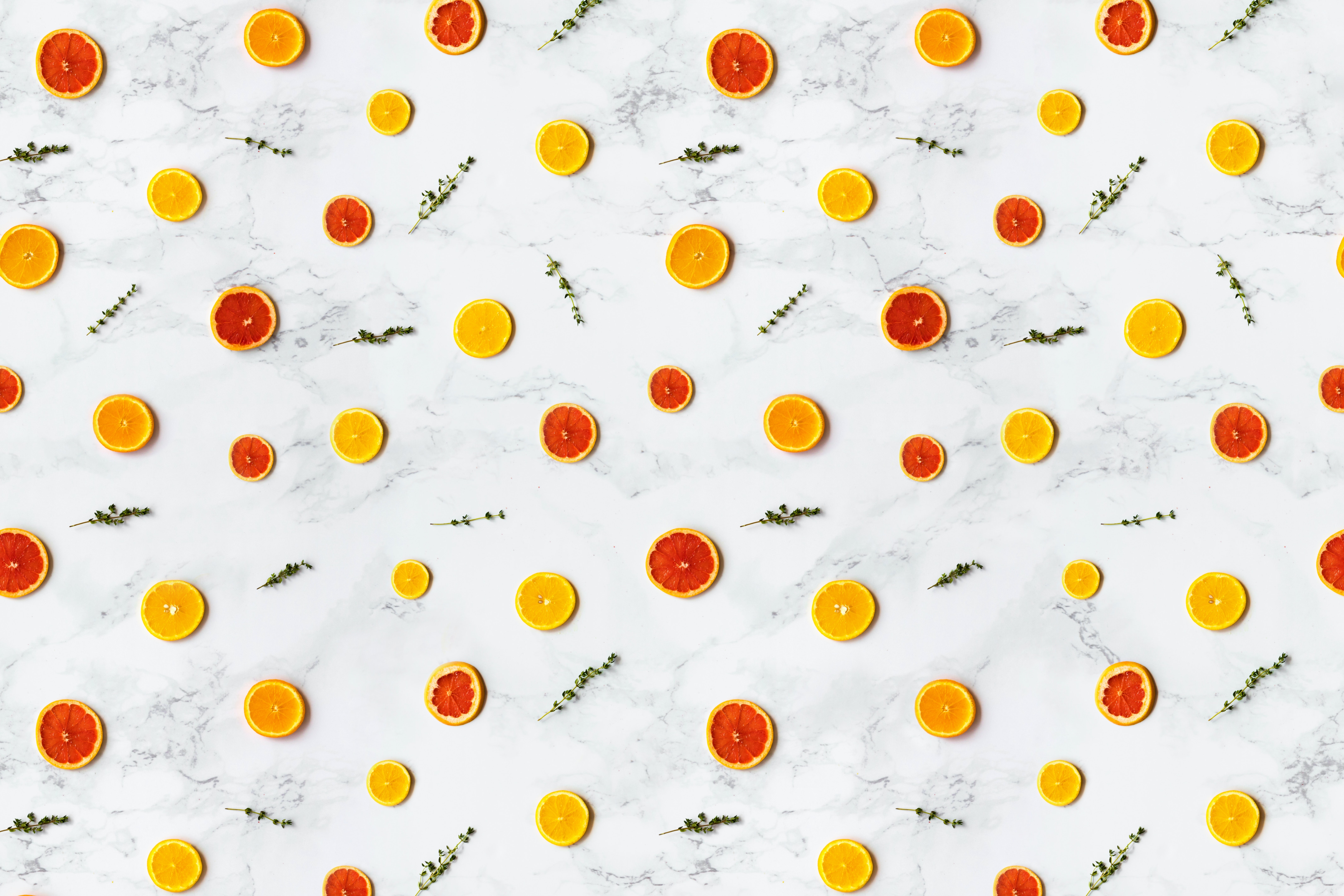 La imagen muestra un estampado regular de rodajas de frutas cítricas naranjas y amarillas.