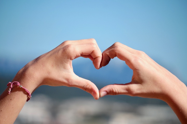 La imagen muestra dos manos haciendo un corazón con la posición de los dedos.