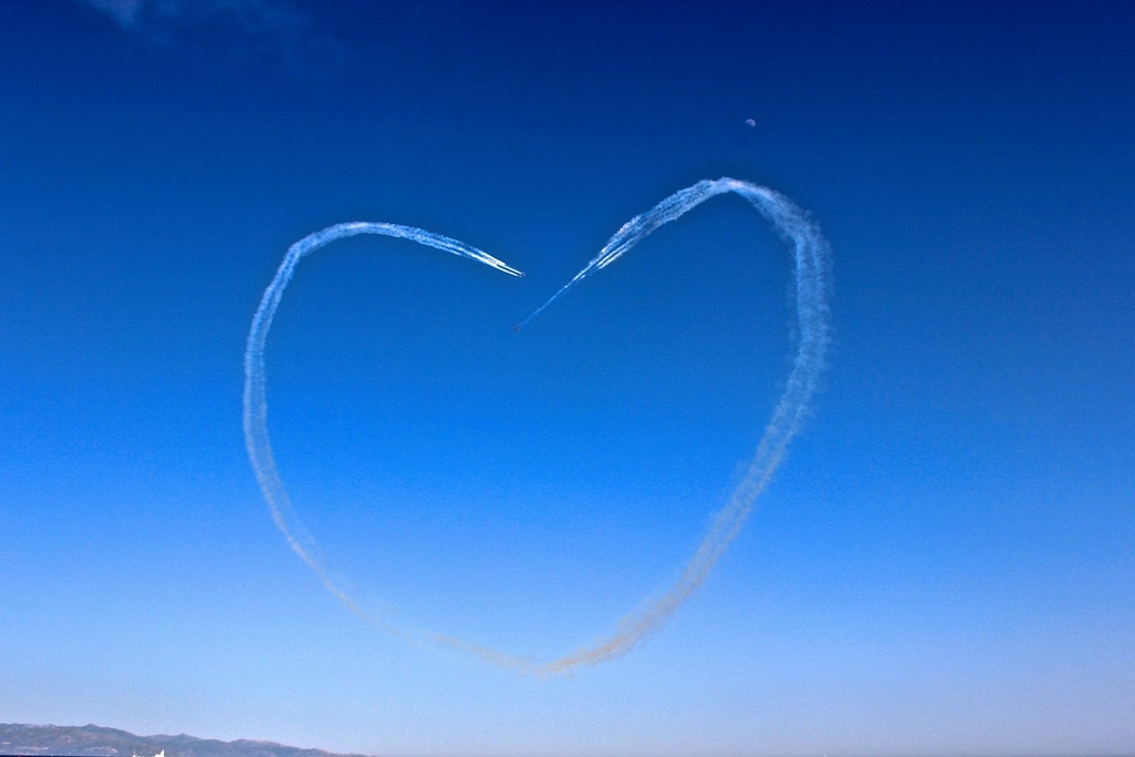 La imagen muestra la estela de un avión en el cielo con forma de corazón.