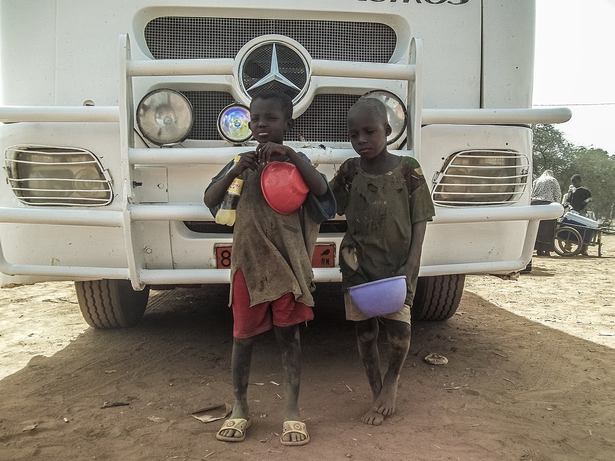 La imagen muestra a dos niños africanos en situación de pobreza.