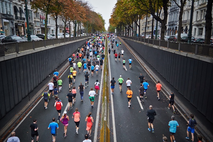 La imagen muestra gente participando en una carrera urbana.