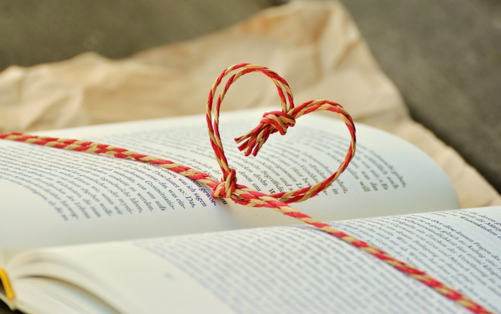 La imagen muestra un libro abierto sobre el que aparece un corazón hecho de cuerdas.