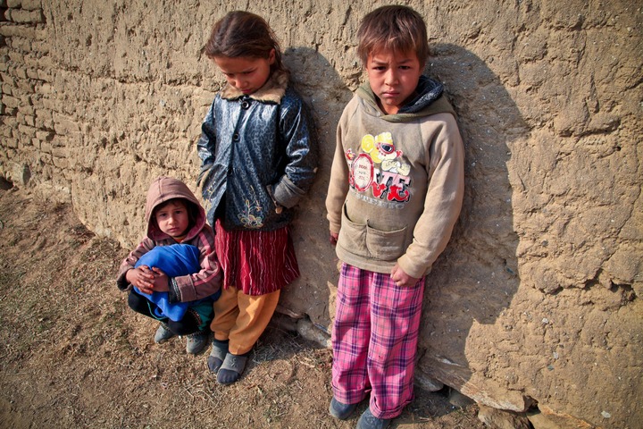 La imagen muestra a tres niños sin hogar y en malas condiciones de vida. 