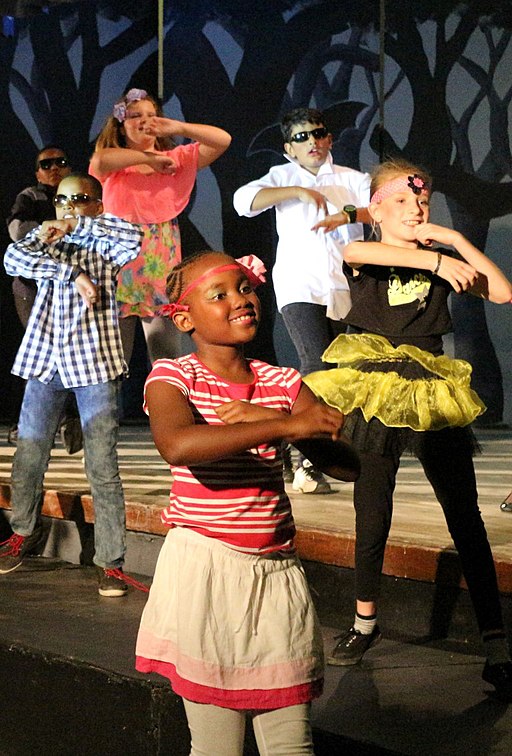 La imagen muestra varios niños bailando