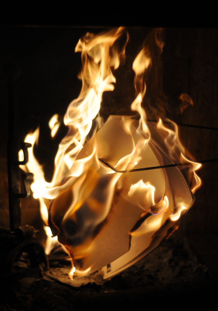 La imagen muestra unos folios ardiendo en una chimenea.