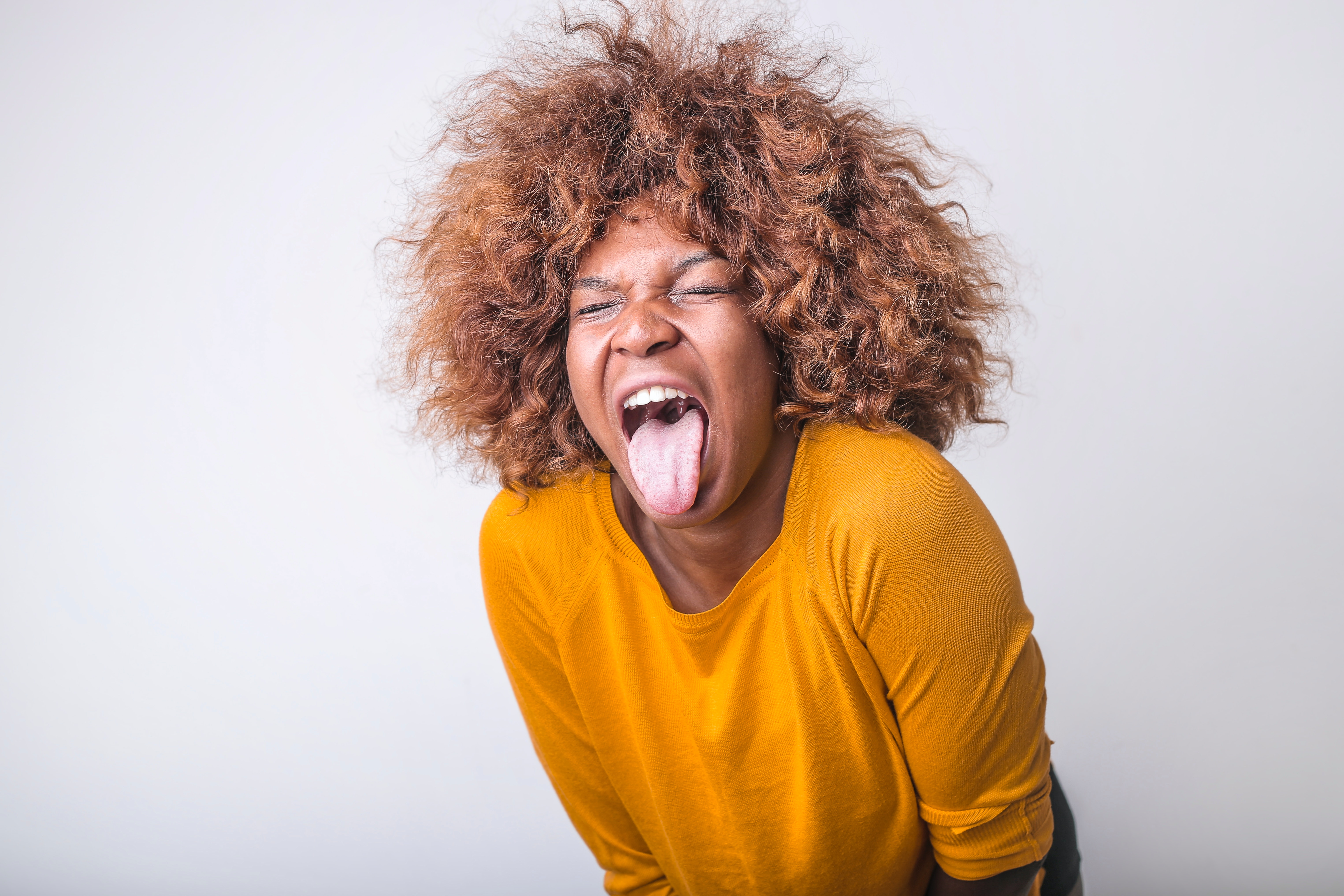 La imagen muestra una mujer que saca la lengua en señal de repugnancia o rechazo.