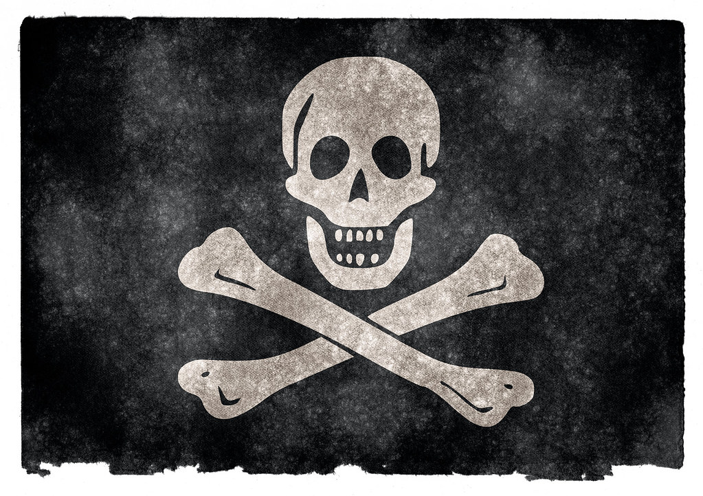 La imagen muestra una bandera pirata con un cráneo y dos huesos cruzados sobre un fondo negro.