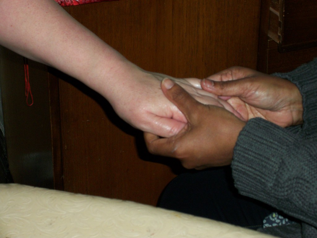La imagen muestra un primer plano de las manos de una persona mientras sostienen la de otra.