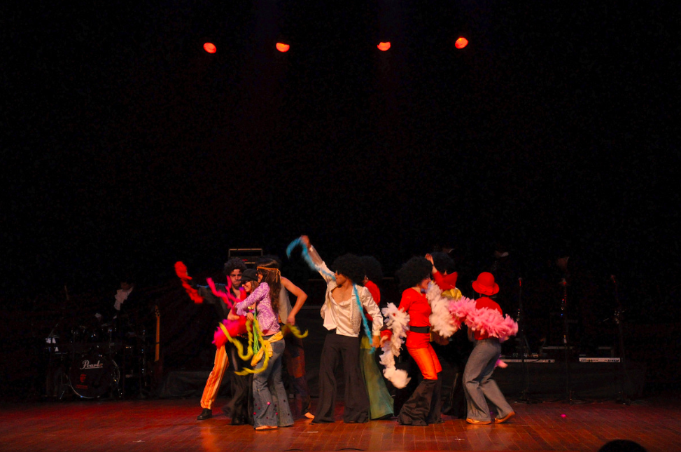 La imagen muestra un grupo de personas disfrazadas encima de un escenario.
