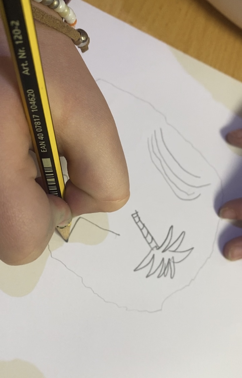 La imagen muestra una mano realizando un dibujo de una palmera.