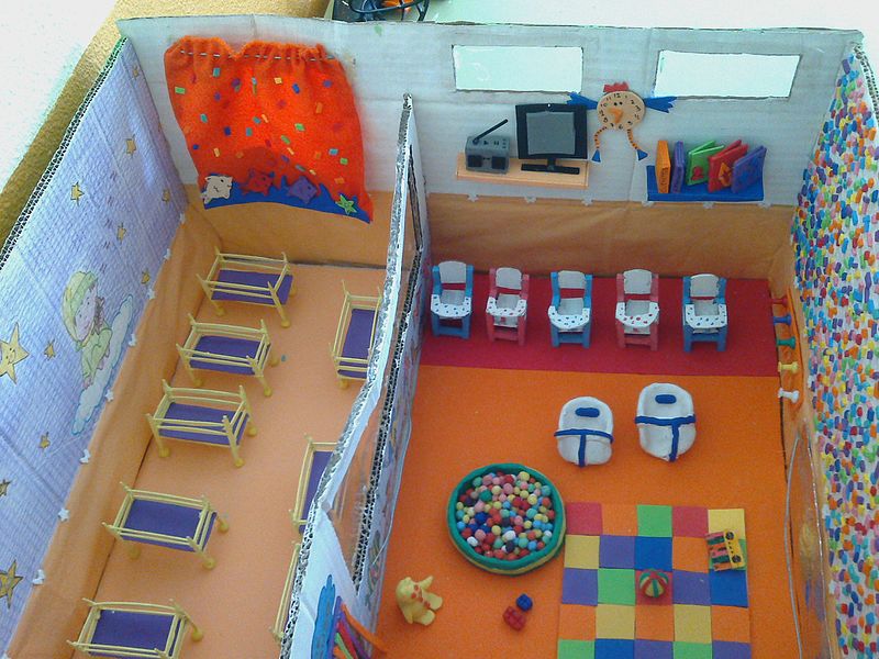 La imagen muestra una maqueta de una escuela, realizada con materiales reciclables.