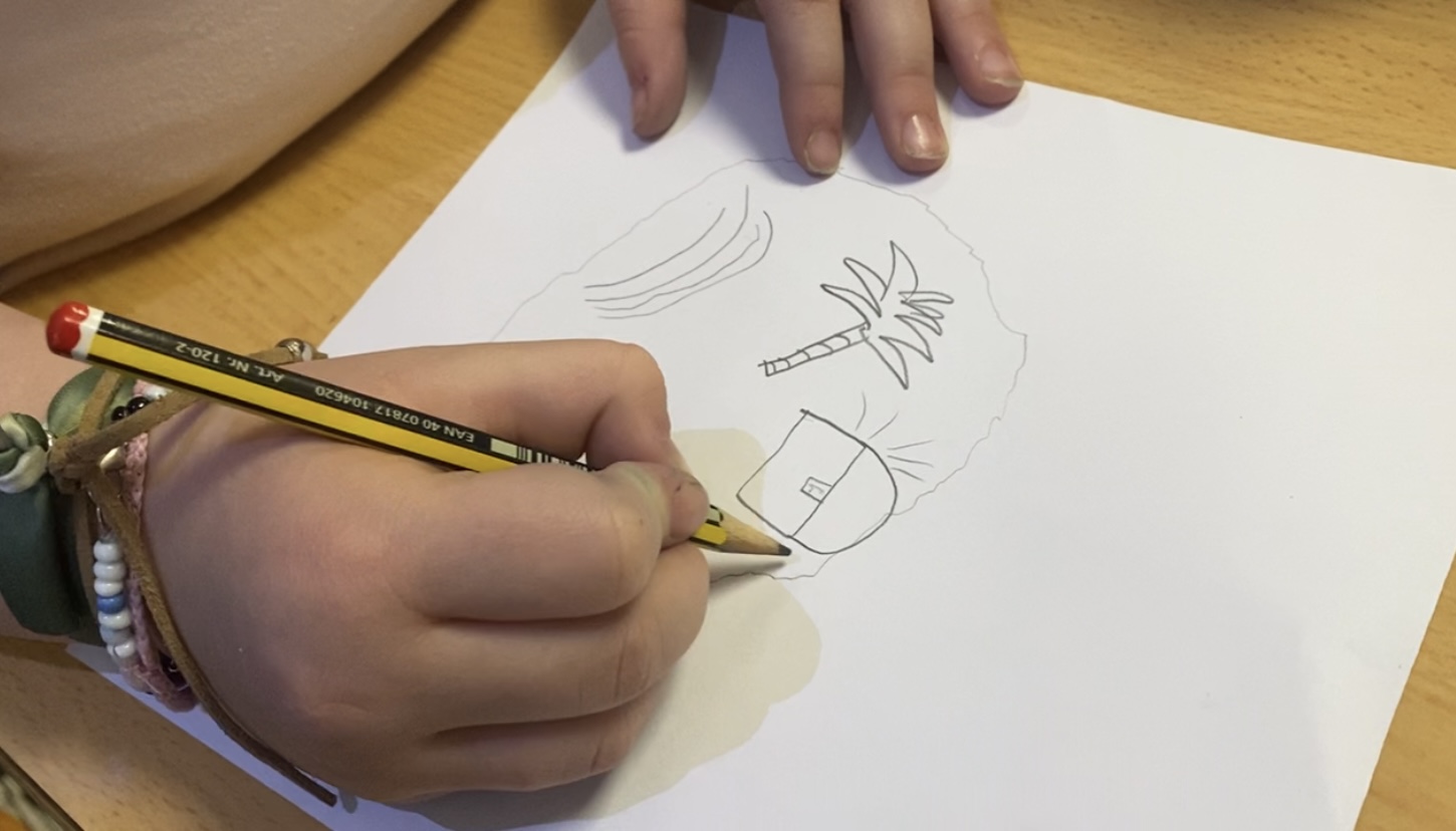 La imagen muestra una mano realizando un dibujo.