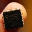 Imagen donde se ve un microcontrolador en la yema de un dedo.