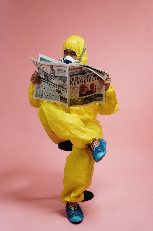 Una persona vestida con atuendo de protección médica, leyendo una noticia que se ha hecho  viral.
