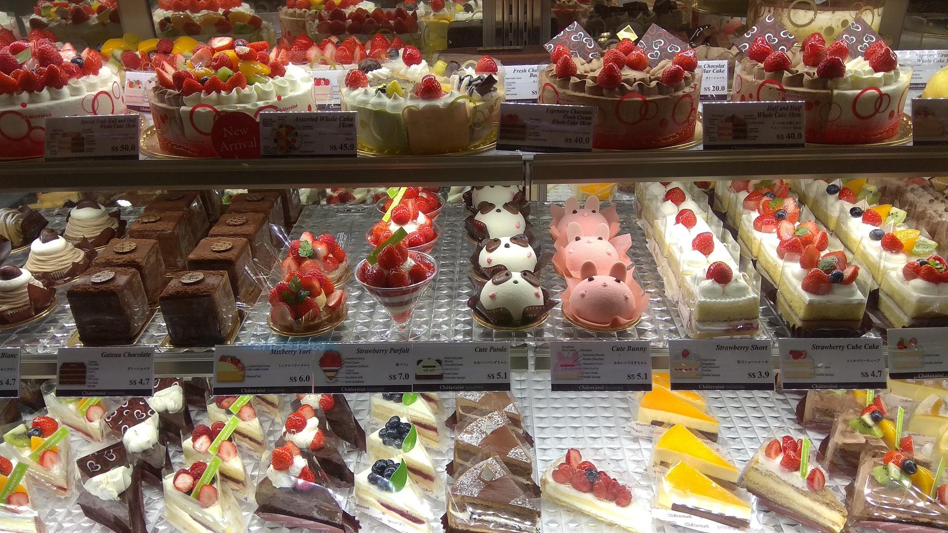 fotografía del mostrador de una pastelería con una gran variedad de dulces y pasteles