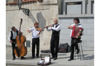 La imagen muestra unos músicos tocando en las calles de Praga, República Checa