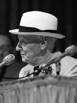 La imagen muestra a un señor de edad avanzada cantando.