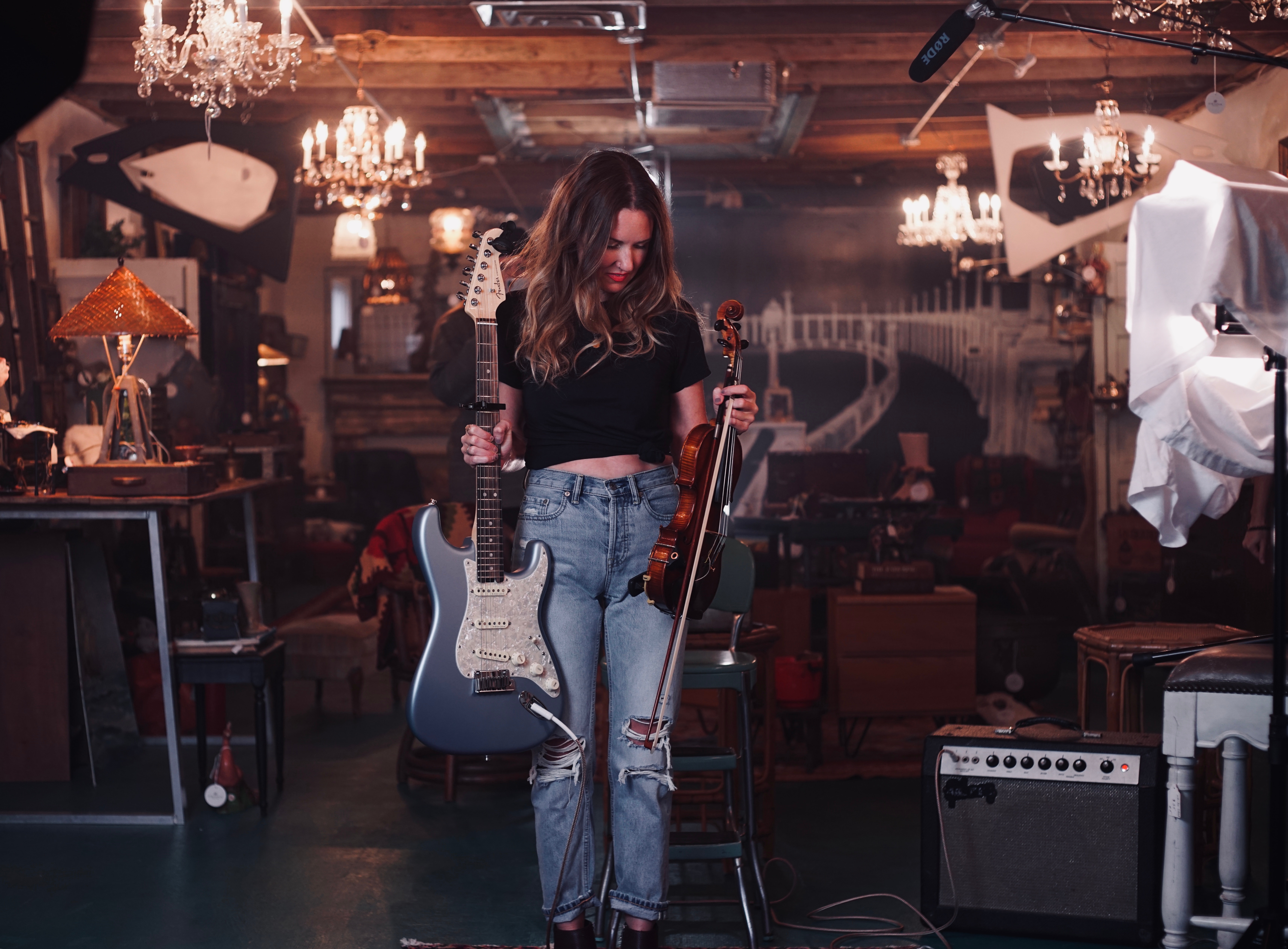 La imagen muestra una chica con una guitarra y un violín