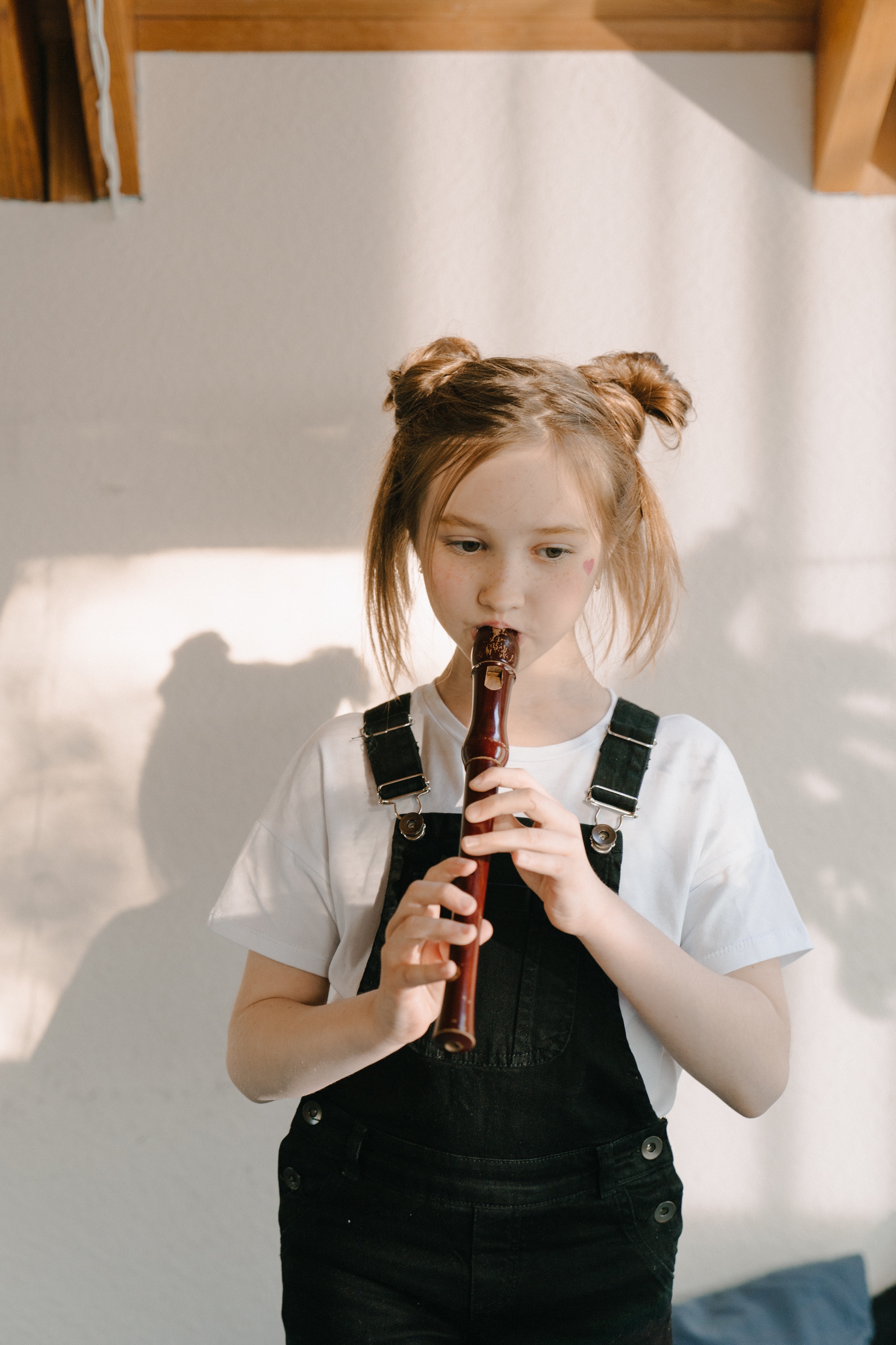 La imagen muestra a una niña tocando la flauta.