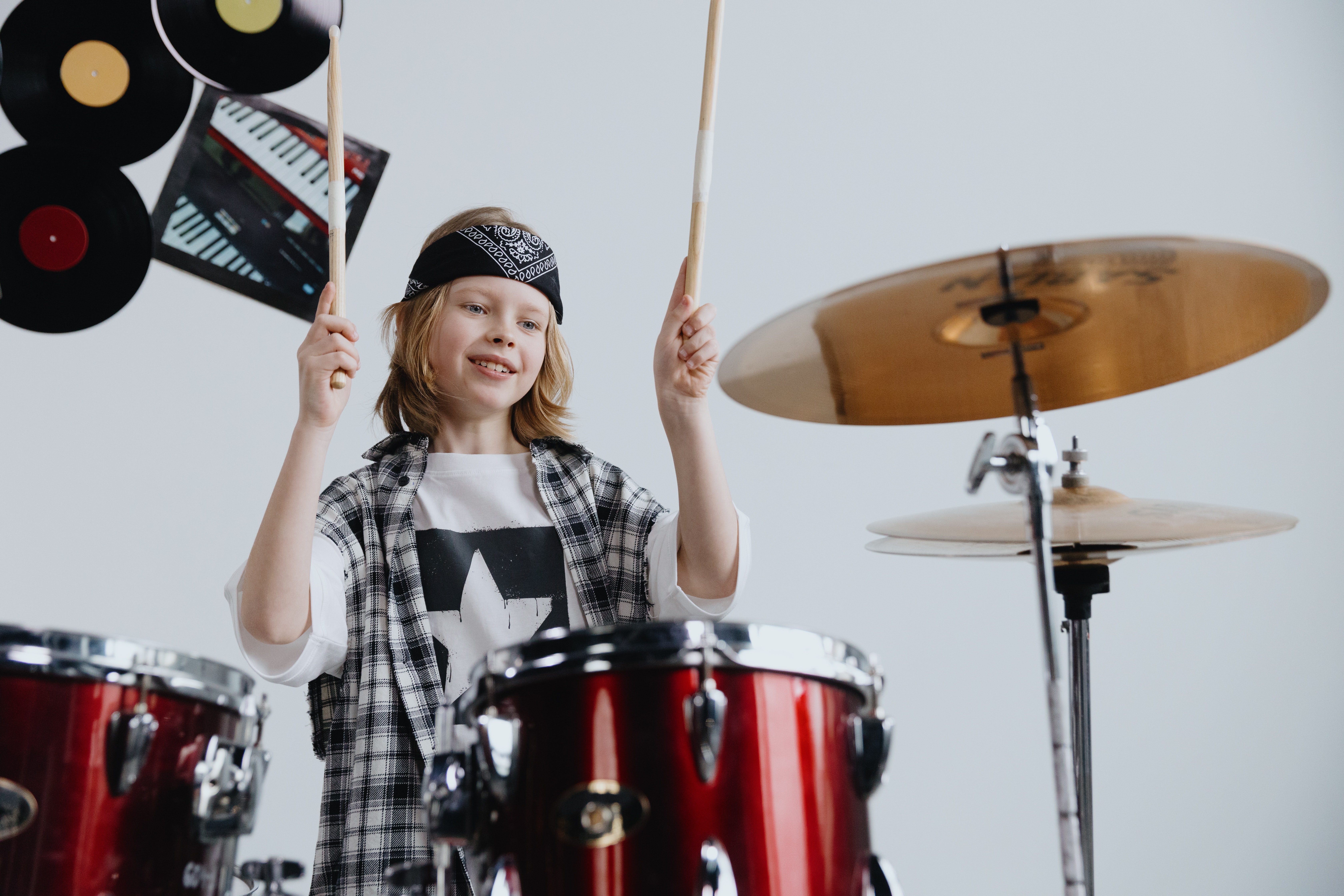 La imagen muestra a un niño tocando la batería.