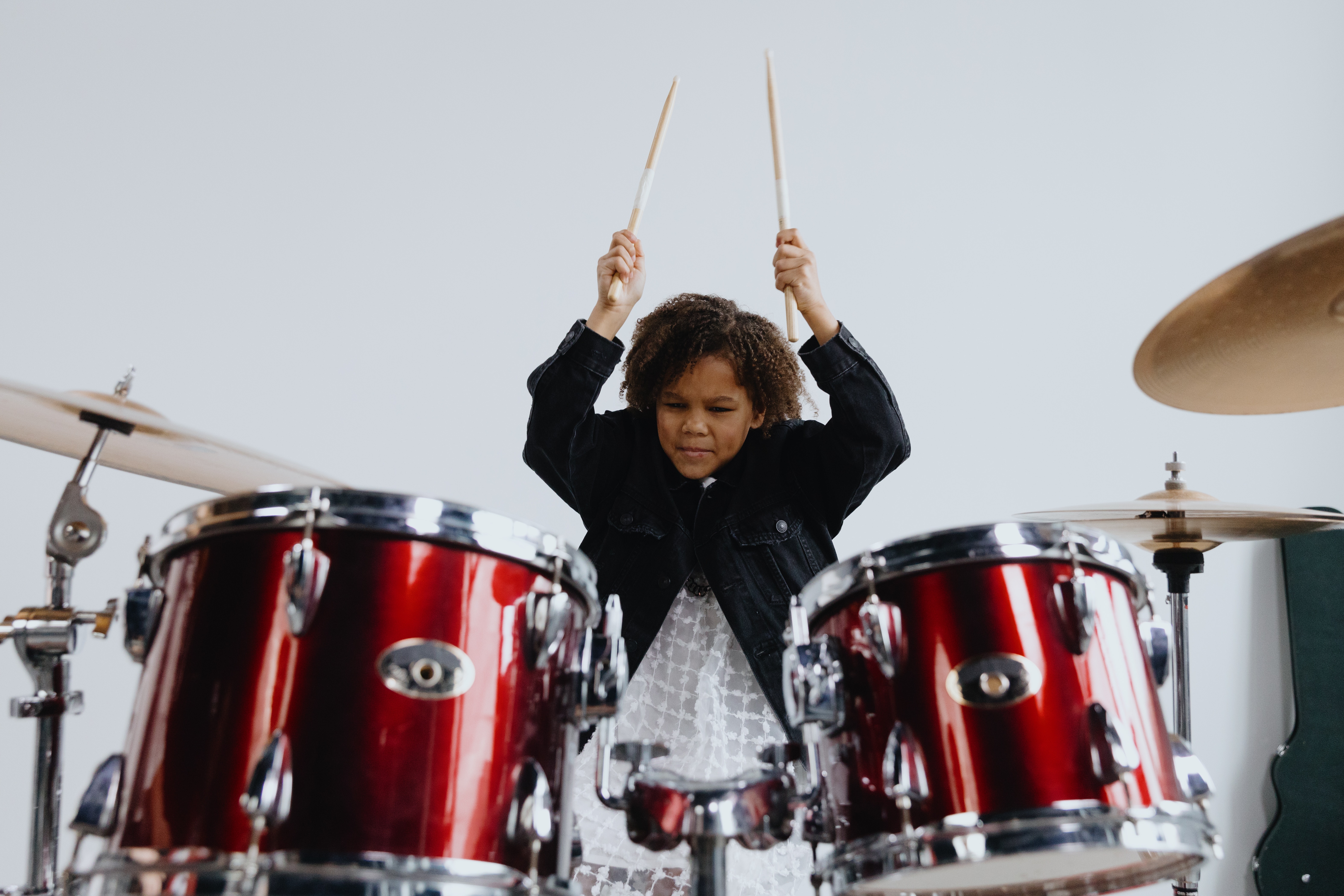 La imagen muestra a un niño tocando la batería.