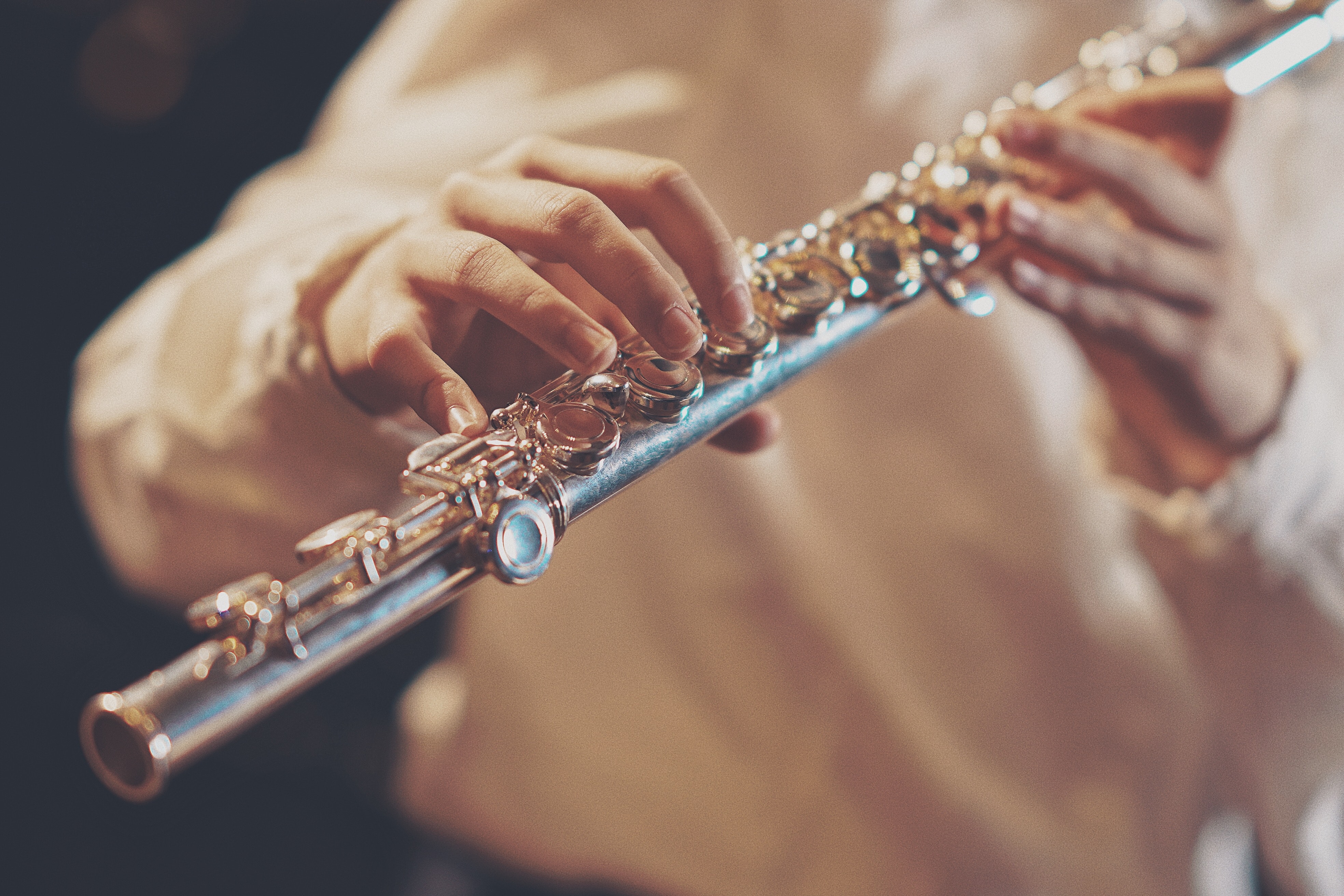 La imagen muestra unas manos tocando una flauta.