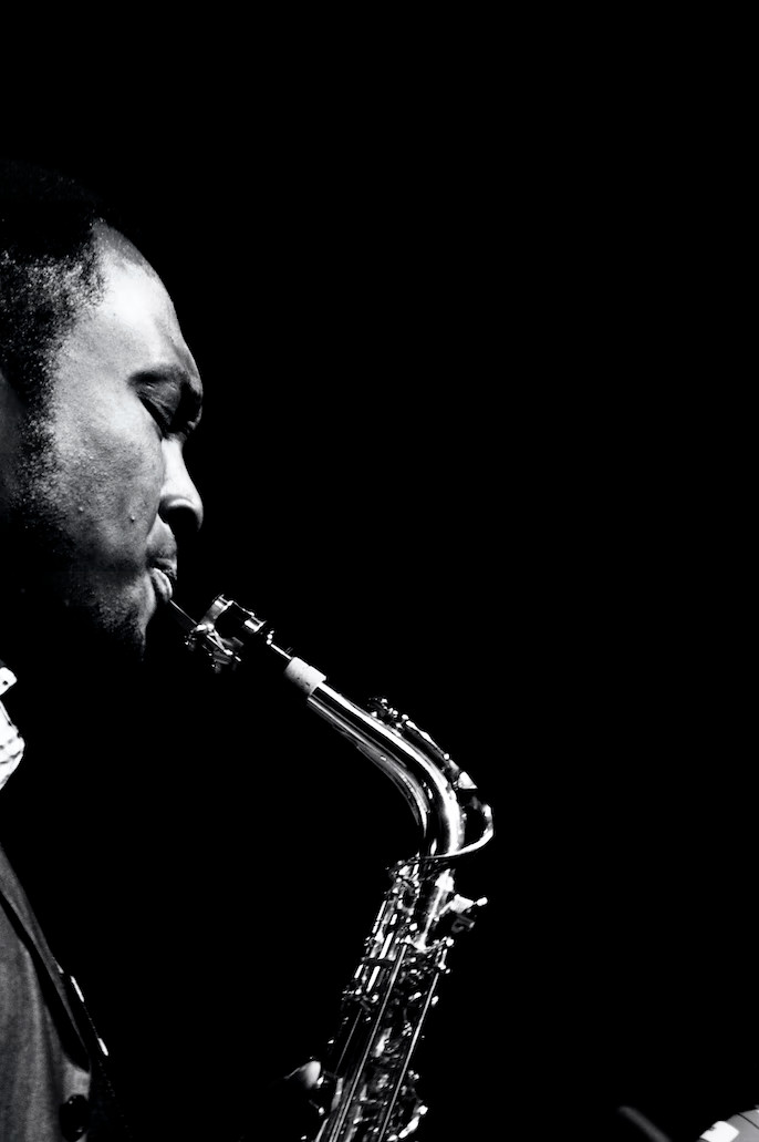 La imagen muestra hombre de perfil tocando el saxo