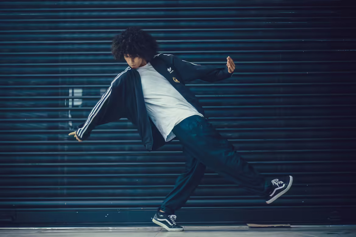 La imagen muestra un adolescente bailando delante de la puerta de un garaje