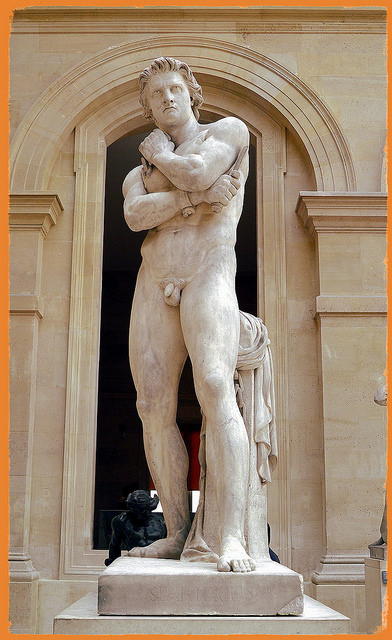 La escultura muestra al gladiador en actitud pensativa con las cadenas rotas en una mano y una espada en la otra