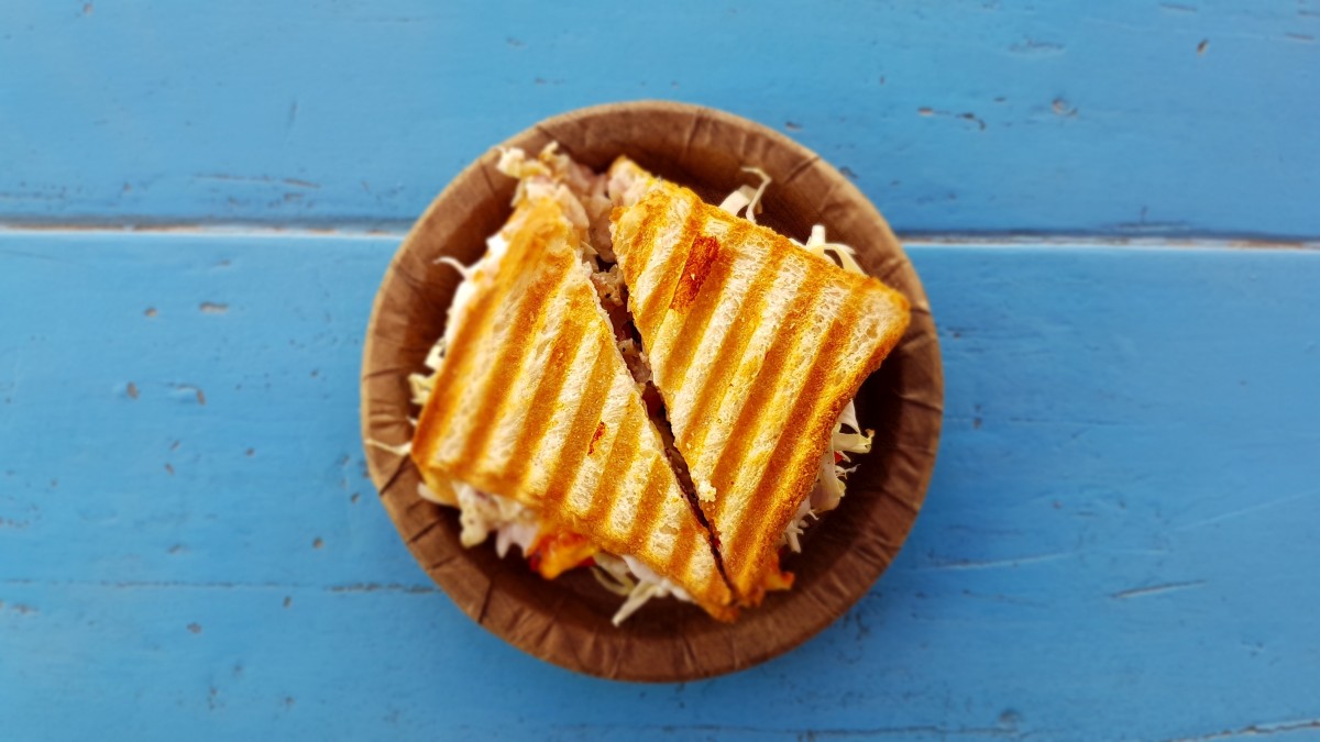 En la imagen se puede ver un sandwich partido por la mitad y colocado en un plato