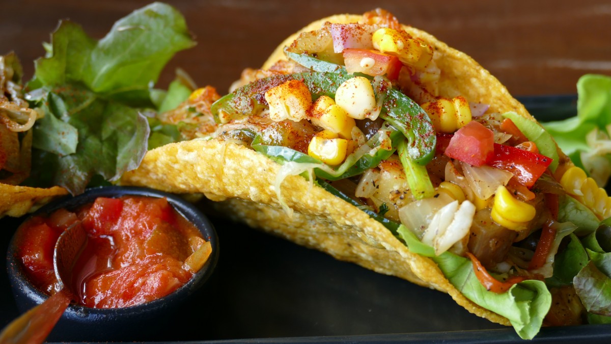 En la imagen puedes ver un taco mexicano con verdura y salsa