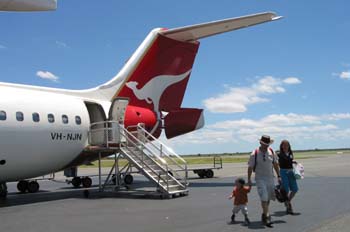 La imagen muestra una familia bajando de un avión.